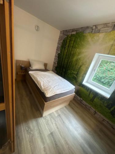 a bedroom with a bed and a painting on the wall at Gästehaus Graupner-Hainichen in Hainichen