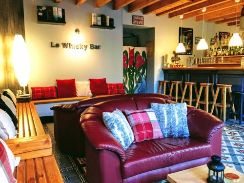 a living room with a leather couch and a bar at Chabanettes Hotel & Spa in Auzelles