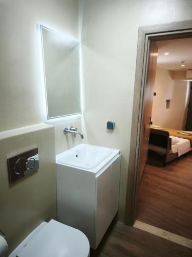 a bathroom with a white sink and a toilet at Agapi's Nest in Agápi