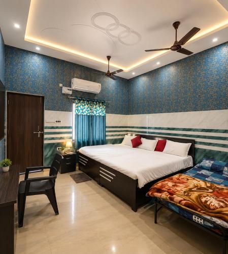 a bedroom with a bed and a chair in it at Bholenath Guest House 500 Mitter From Shree Ram Manidr in Faizābād
