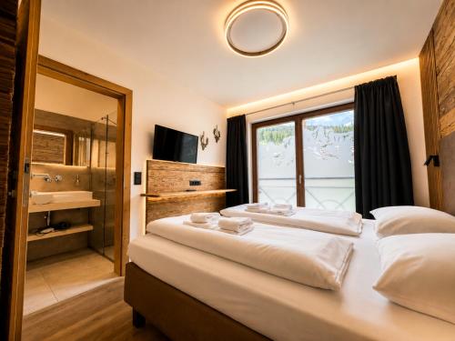 a bedroom with two beds and a large window at Mountain Lodge Leogang-Premium Apartment, Balkon, Bergblick, Kamin, Sauna in Leogang
