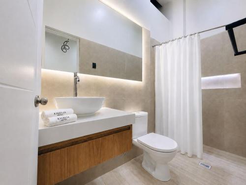 a bathroom with a white sink and a toilet at Kigelia Hotel in Tumbes