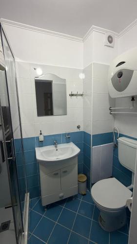 a blue and white bathroom with a toilet and a sink at Sab Luxury Apartments in Saturn