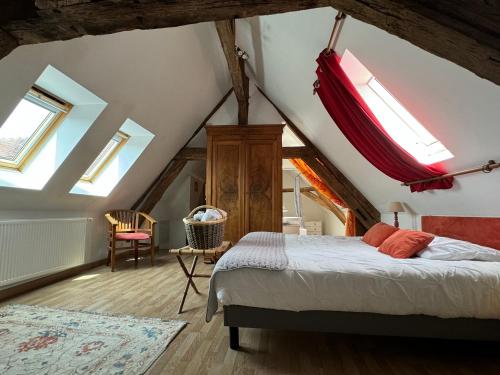 a bedroom with a bed in a attic with skylights at Maison Borgnat domaine viticole in Escolives-Sainte-Camille