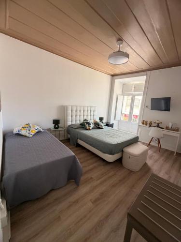 a bedroom with two beds and a television in it at Maria's in Faro