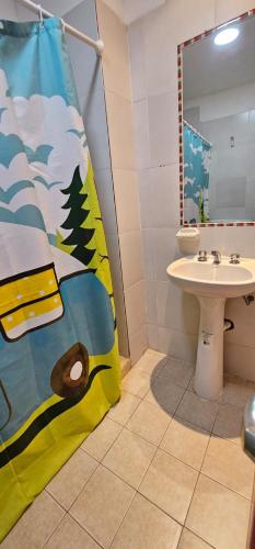 a bathroom with a bed and a sink and a mirror at Apartamentos El Fortín in San Salvador de Jujuy
