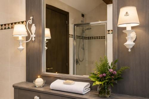 a bathroom with a sink with two lights and a mirror at Villa Al Sicomoro in Grezzana