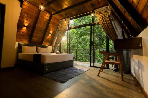 a bedroom with a bed and a large window at Forest Face Lodge in Gurudeniya