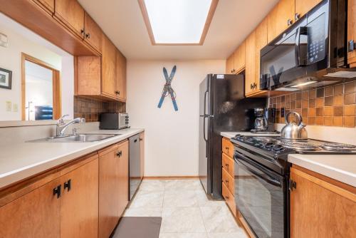 a kitchen with wooden cabinets and a stainless steel refrigerator at Village Square West 353 in Copper Mountain