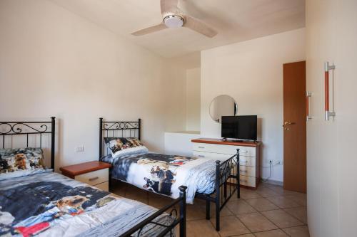 a bedroom with two beds and a tv at Casa Stella Marina in Cervia