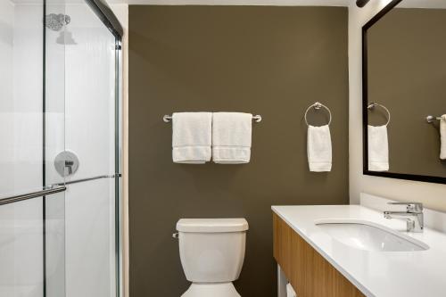 a bathroom with a toilet and a sink and a shower at Spark by Hilton Edmundston in Edmundston