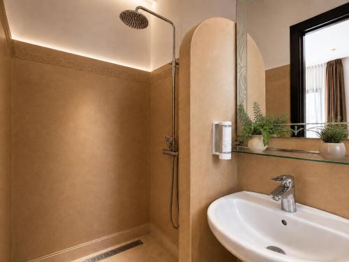 a bathroom with a sink and a shower at Ourika Camp Suites Hotel & Resort in Marrakesh