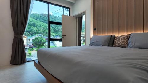a bedroom with a large bed with a large window at Zoha 2BR Private Pool Villa Bangtao in Thalang
