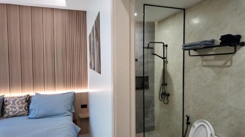 a bedroom with a shower and a bed with blue pillows at Zoha 2BR Private Pool Villa Bangtao in Thalang