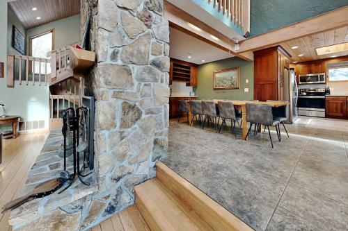 a stone fireplace in a living room with a table and chairs at Shoreline Chateau in Swanton