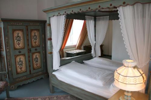 a bedroom with a canopy bed and a table with a lamp at Landgasthof Hotel Bechtel in Zella
