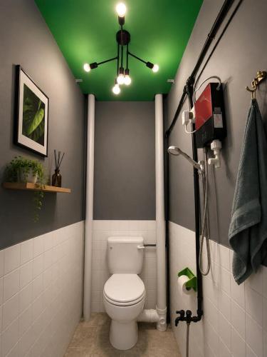 a bathroom with a toilet and a green ceiling at F1 Riverside Mee Udang in Malacca