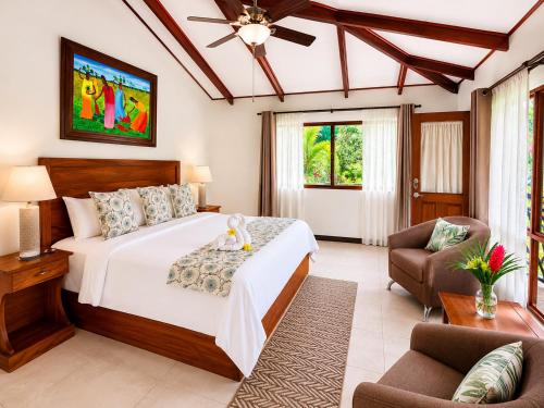a bedroom with a bed and a couch and a chair at Hotel Playa Espadilla in Manuel Antonio