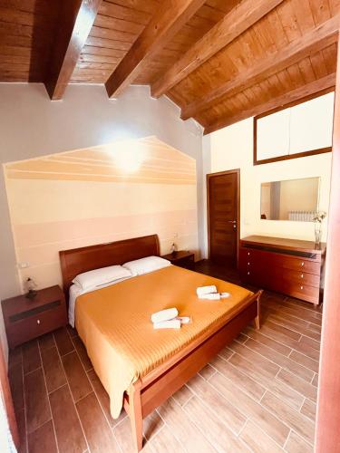 a bedroom with a large bed and a mirror at Appartamento in casale rustico - La Masseria in Busso