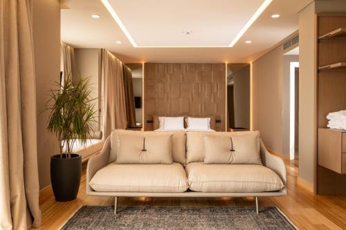 a living room with a couch in front of a bed at Kraal Hotel Vlore in Vlorë