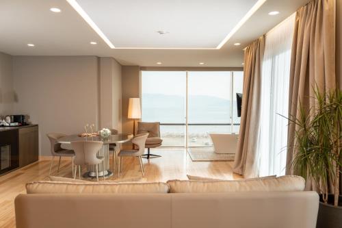 a living room with a couch and a table with chairs at Kraal Hotel Vlore in Vlorë