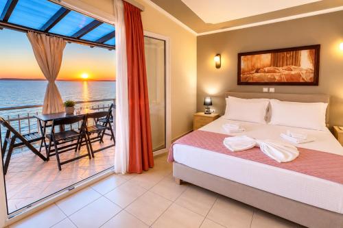 a bedroom with a bed and a view of the ocean at Studios Plaka in Skala Kallirachis