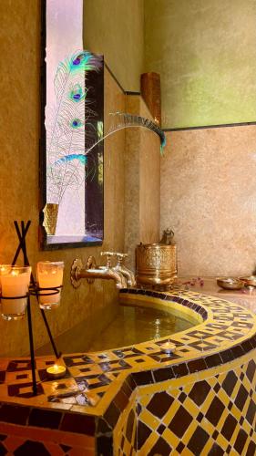 a bathroom with a tub with a tiled floor at Daba Riads in Marrakesh