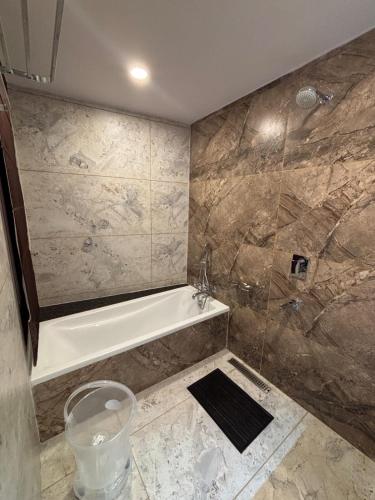 a bathroom with a bath tub and a shower at Jayati Palace Hotel in Rudraprayāg