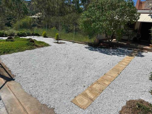a yard with gravel and a walkway at Anemolia Tiny Stone House in Palekastron