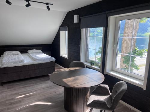 a bedroom with a bed and a table and chairs at Jolster SPA apartments for 2 in Skei