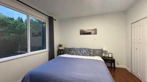 a bedroom with a bed and a large window at Richmond Cozy Place 2 in Richmond