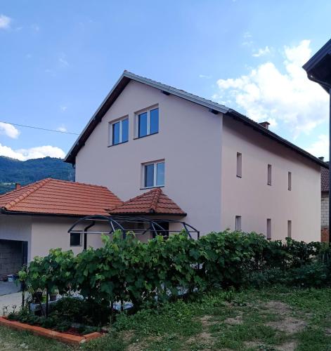 a large white house with a hedge in front of it at Kuća - Šekovići in Šekovići