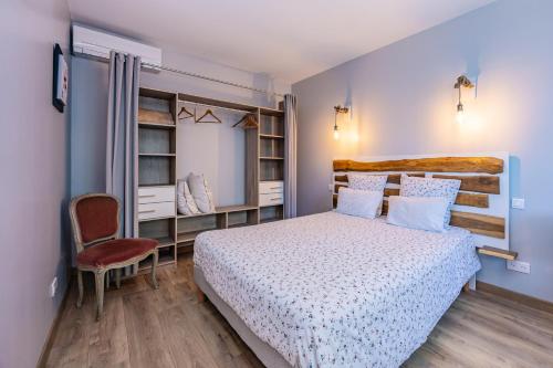 a small bedroom with a bed and a chair at Les Hauts de Grazac, Chambres et Tables d'hôtes in Grazac