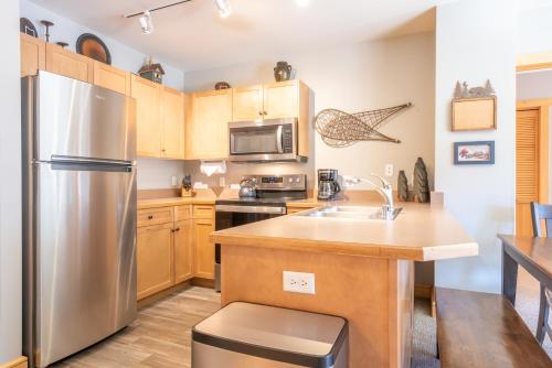 a kitchen with stainless steel appliances and wooden cabinets at Copper Springs Lodge 301 in Copper Mountain