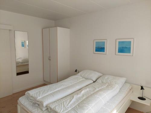 a white room with a bed and a white couch at Tversted Strandkro in Bindslev