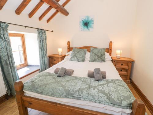 a bedroom with a large bed with two pillows at Stabal-y-Gwedd in Llanddulas