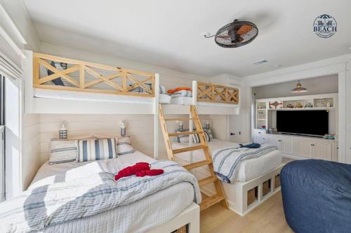 a bedroom with two bunk beds and a tv at Beach,Please in Rosemary Beach