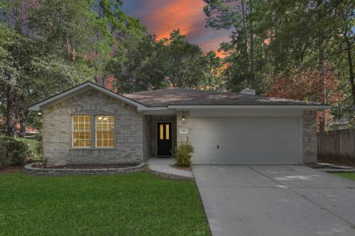 una piccola casa con un garage in un cortile di Drifting Shadows a Conroe