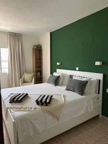 a bedroom with a large white bed with a green wall at Costamar Oceanview 1 Bed Apartment in Arona