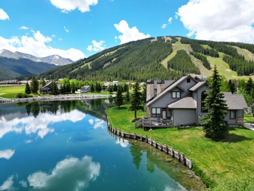 a house on a hill next to a river at Woods12 Townhome Pet Friendly in Copper Mountain