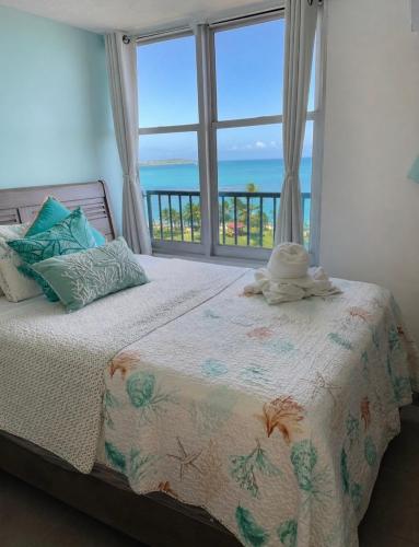 a bedroom with a bed with a view of the ocean at Private Island Oceanview Condo in Fajardo