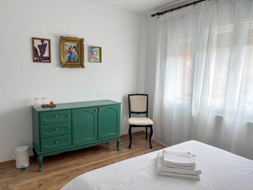 a bedroom with a green dresser and a chair at Dabfly Guesthouse & Outdoor Adventures in Ražanj