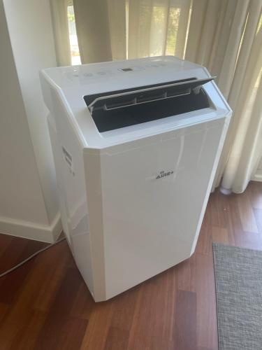 a white printer is sitting on a wooden floor at Destino Allariz in Allariz