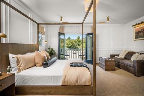 a bedroom with a four poster bed and a couch at Polo House and Bungalows in Santa Ynez