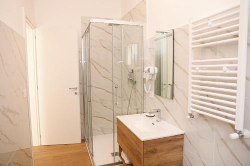 a white bathroom with a sink and a shower at Nina Guest house in Gaeta