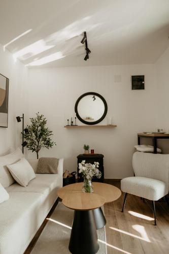 a living room with a white couch and a table at Green Valley Accommodation in Lipovica