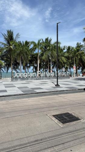 an empty street with palm trees and a sign at View Talay 7 Seaview Apartments in Pattaya South