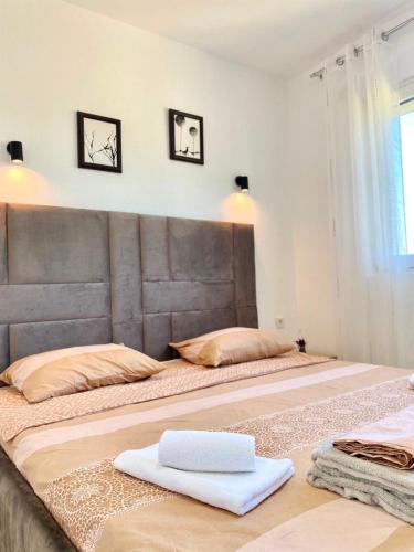 a large bed with a large headboard in a bedroom at Vila Marbela in Seoca