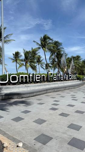 a sign for a resort with palm trees in the background at View Talay 7 Seaview Apartments in Pattaya South