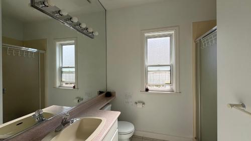 a bathroom with a sink and a mirror and a toilet at Richmond Cozy Place 2 in Richmond
